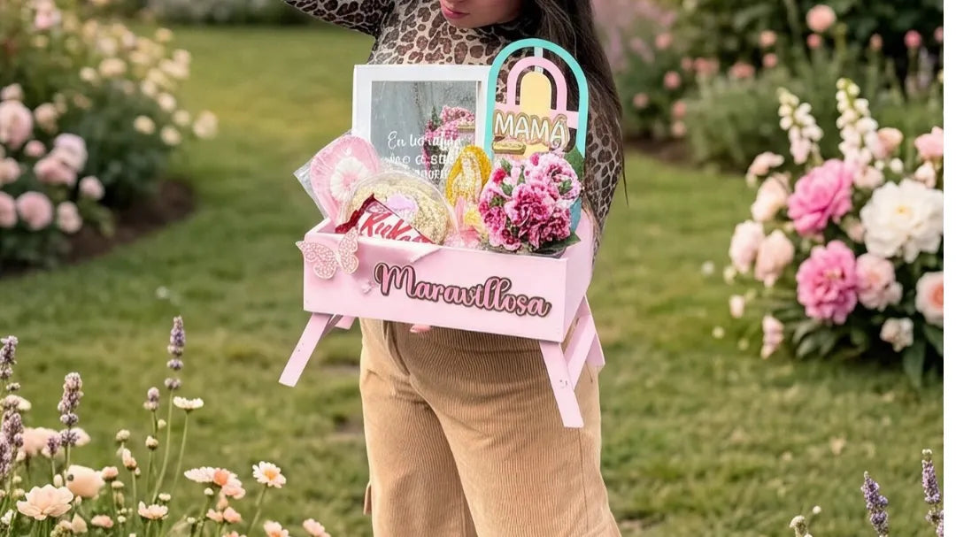 Mujer recibe una ancheta rosada para mamá en un jardín de rosas