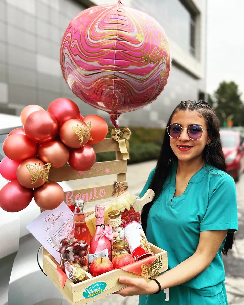 Mujer sonriente sostiene su desayuno sorpresa con globos rojos